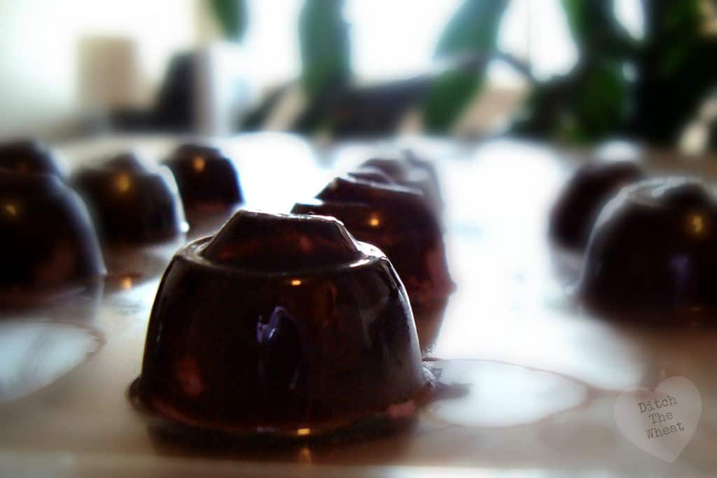 Blueberry fat bombs in a chocolate mold, on a kitchen counter. 
