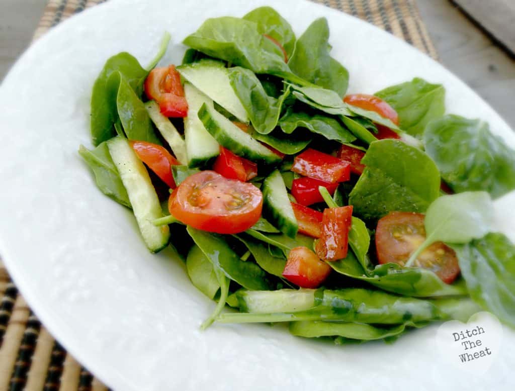 Simple salad dressing over salad on a plate.