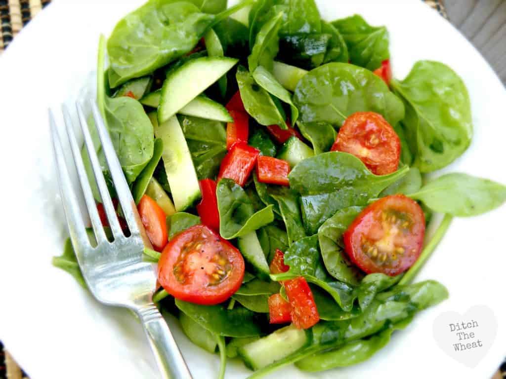 Simple salad dressing over salad on a plate.