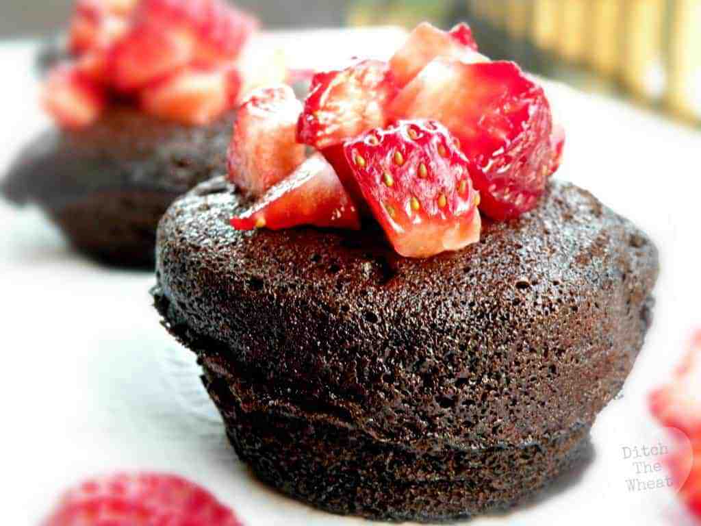 THE BEST FLOURLESS Chocolate Mug Cake with chopped strawberries on it.