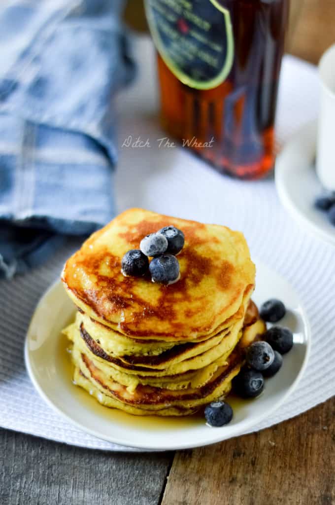 A plate of coconut flour pancakes with fresh blueberries.