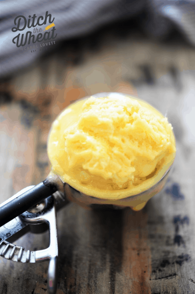 Dairy free mango ice cream in an ice cream scoop.