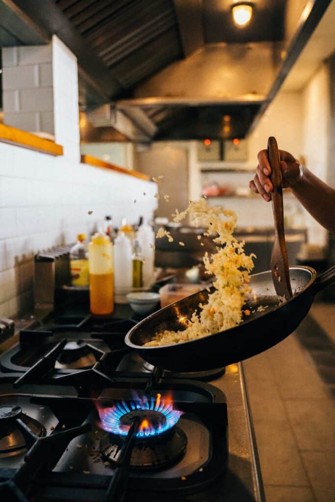 Fried rice tossed in a pan by a chef.