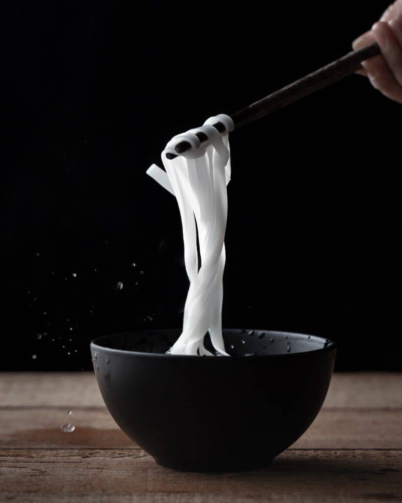 Rice noodles in a bowl with chopsticks. 