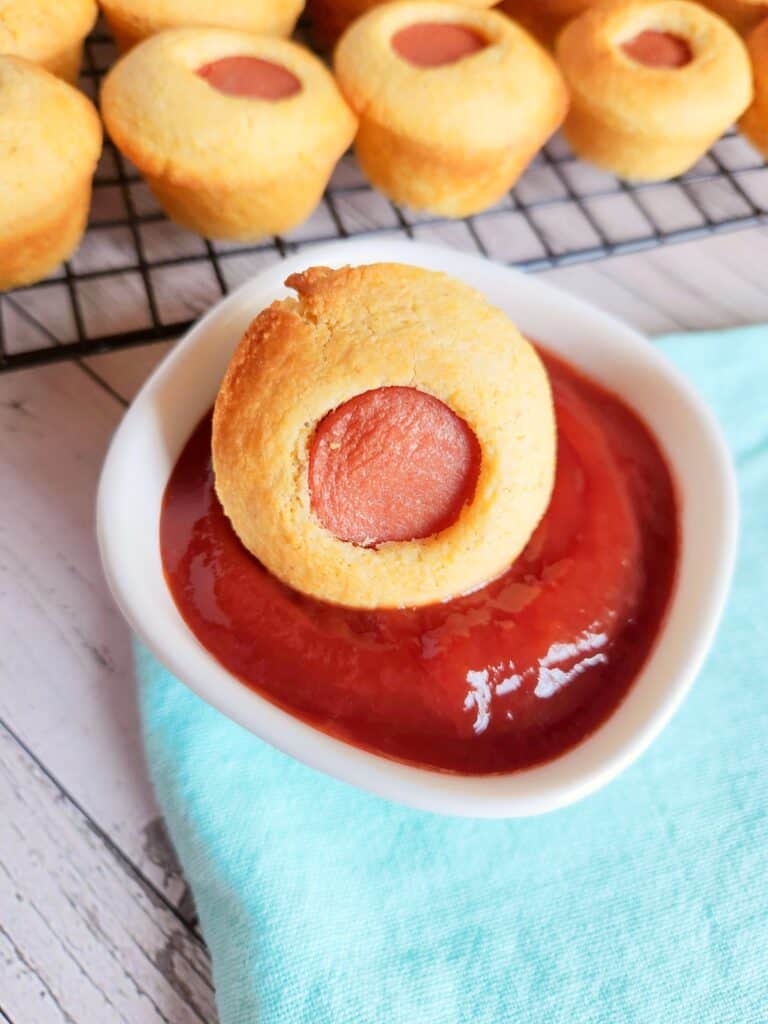 Gluten free corn dog muffins - a mini corn dog is dipped in ketchup