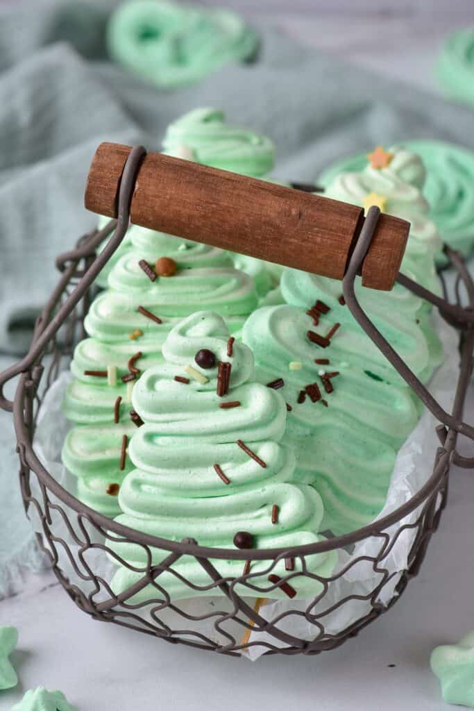 Meringue Christmas Trees on a stick in a basket.