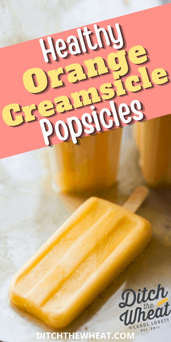 A healthy orange creamsicle popsicle on a grey background.