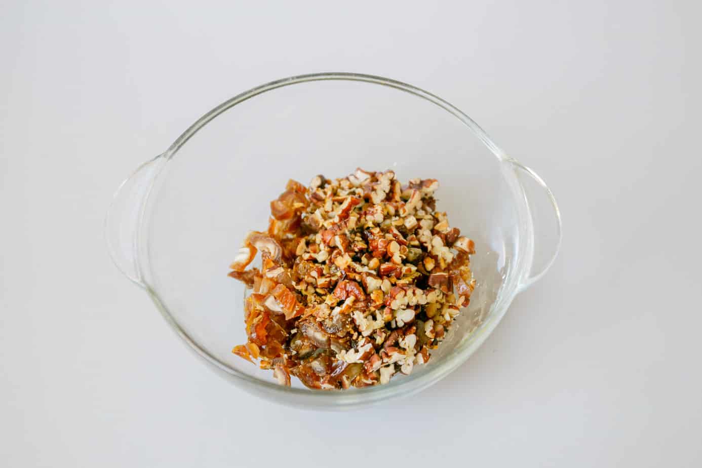 A bowl of chopped pecans and diced dates.