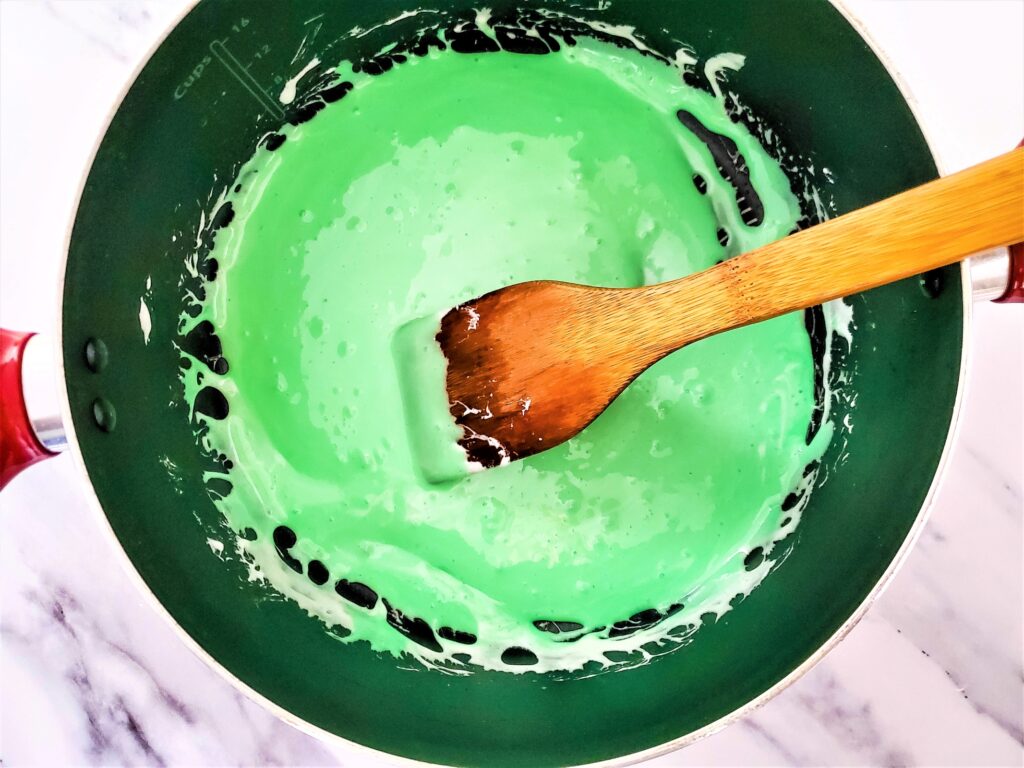 Green melted marshmallows in a pot.