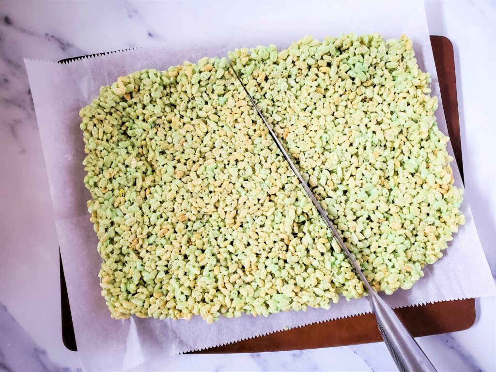Cutting into green rice krispies.