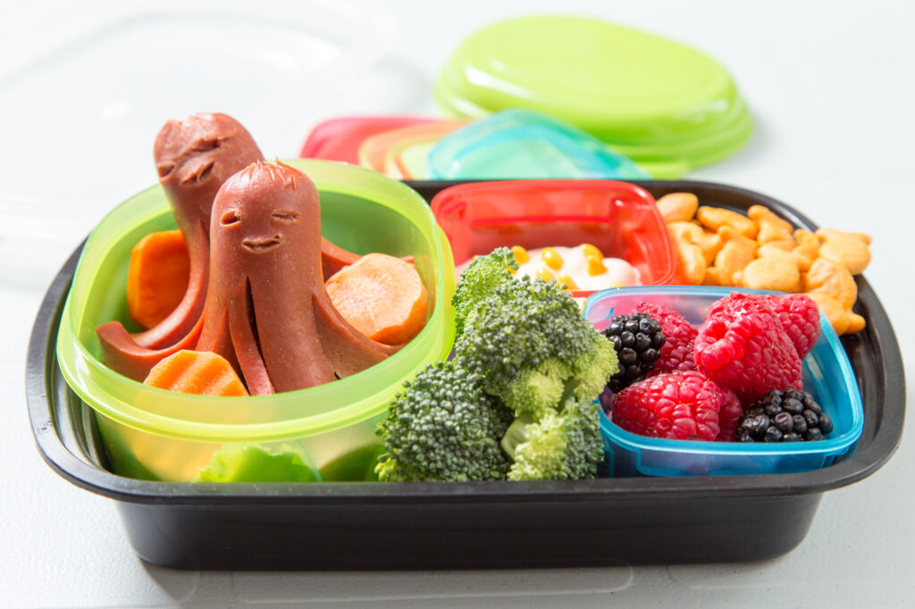 Gluten Free Lunch Ideas For Kids - A lunch box filled with hot dog spiders, broccoli, and berries. 