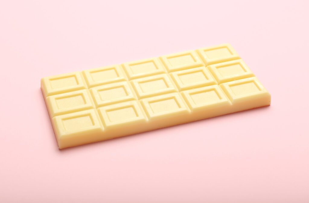 Is White Chocolate Gluten Free? A white chocolate bar on a pink background.