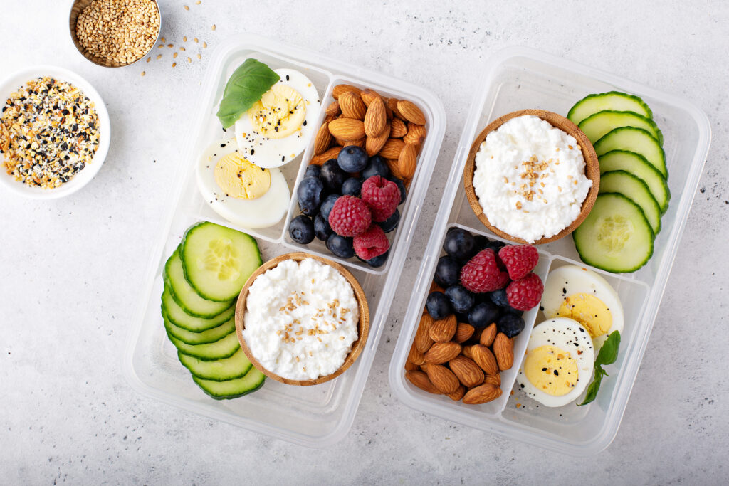 Gluten Free Lunch Ideas For Kids - 2 lunch boxes with hardboiled eggs, cucumbers, cottage cheese, berries, and almonds.