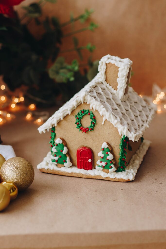 A gingerbread house surrounded by holiday decor.