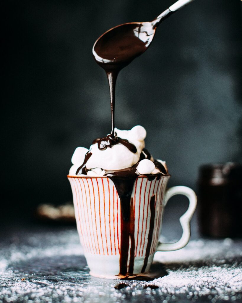Hot chocolate with whipped cream and hot chocolate sauce.