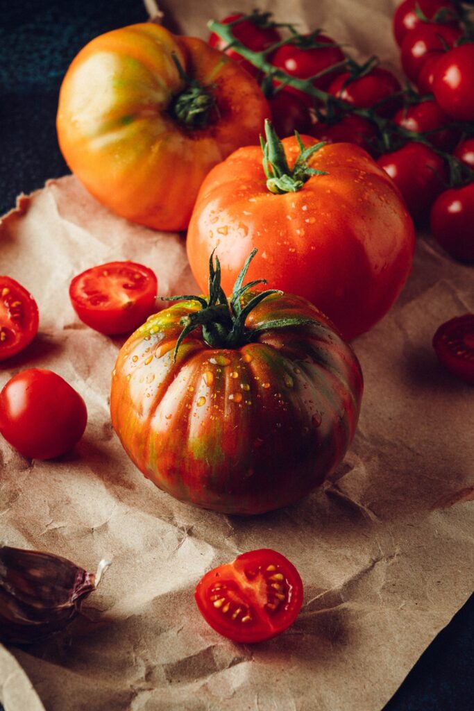 Assorted ripe tomatoes on parchment paper.
