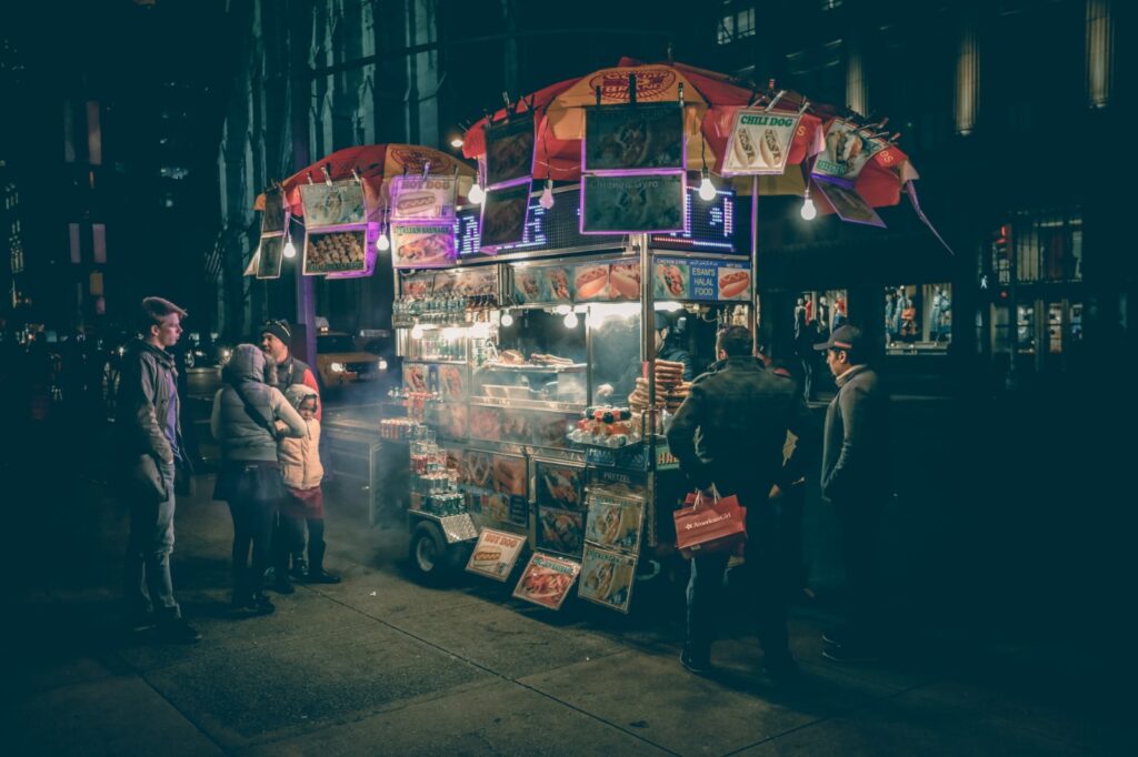 A food cart selling hotdogs and sausages.