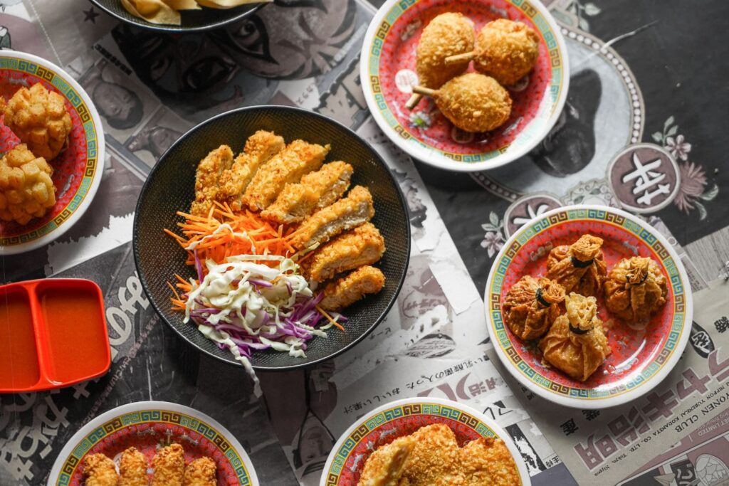 Panko coated chicken in a black bowl with various items.