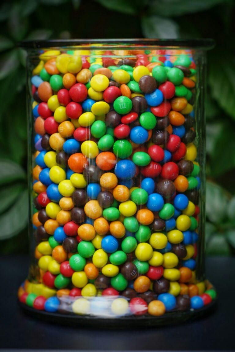 A glass jar filled with M&M's.