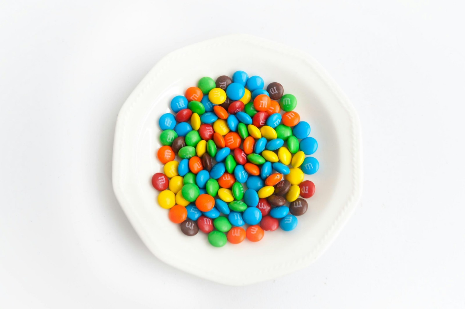 A white plate filled with colorful M&M's.