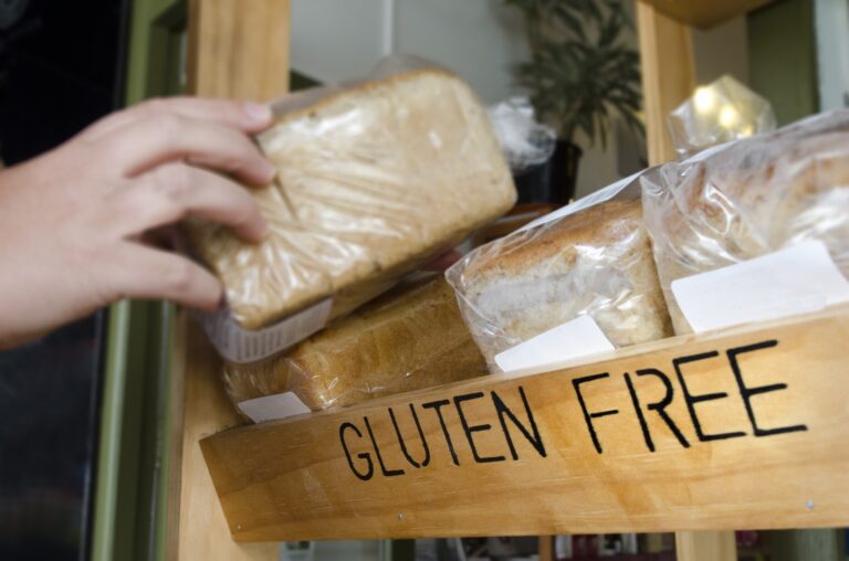 A person reaching for gluten free bread at a store.