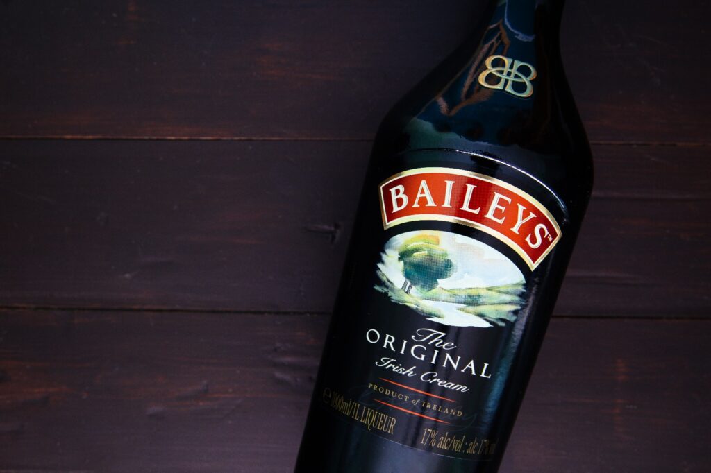 A bottle of Baileys with a dark wooden background.