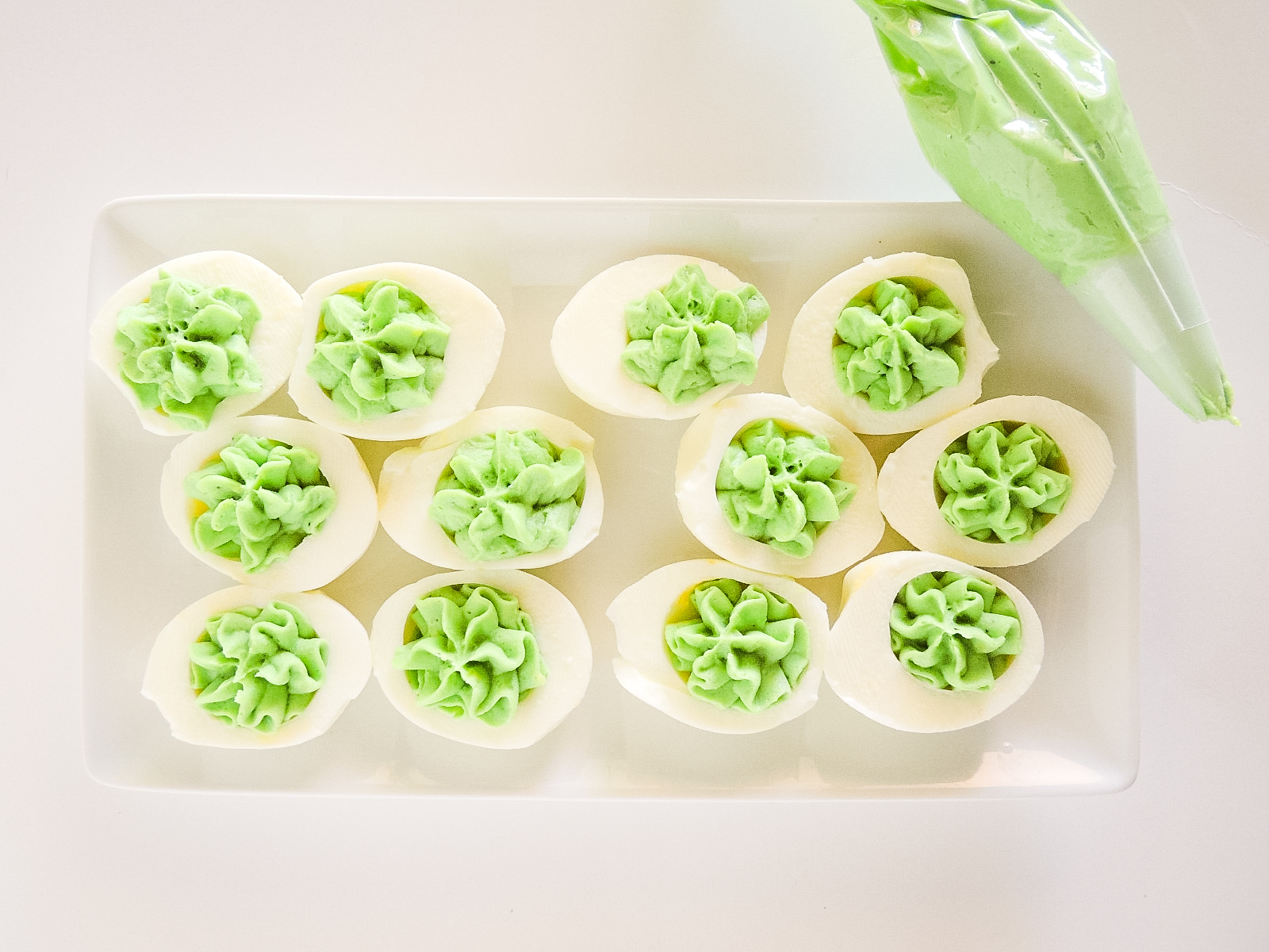 Hard boiled eggs with a green deviled egg filling. 