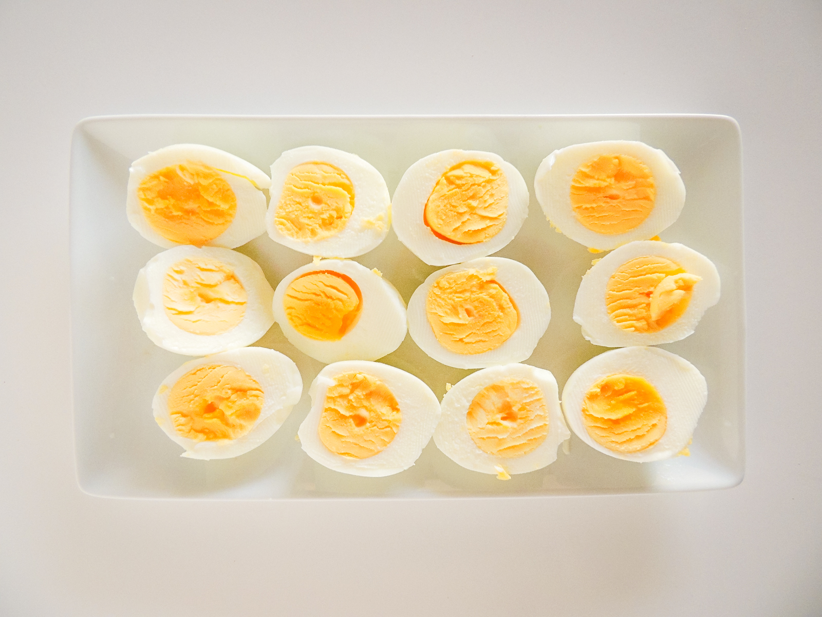 A tray with hard boiled eggs cut in half.