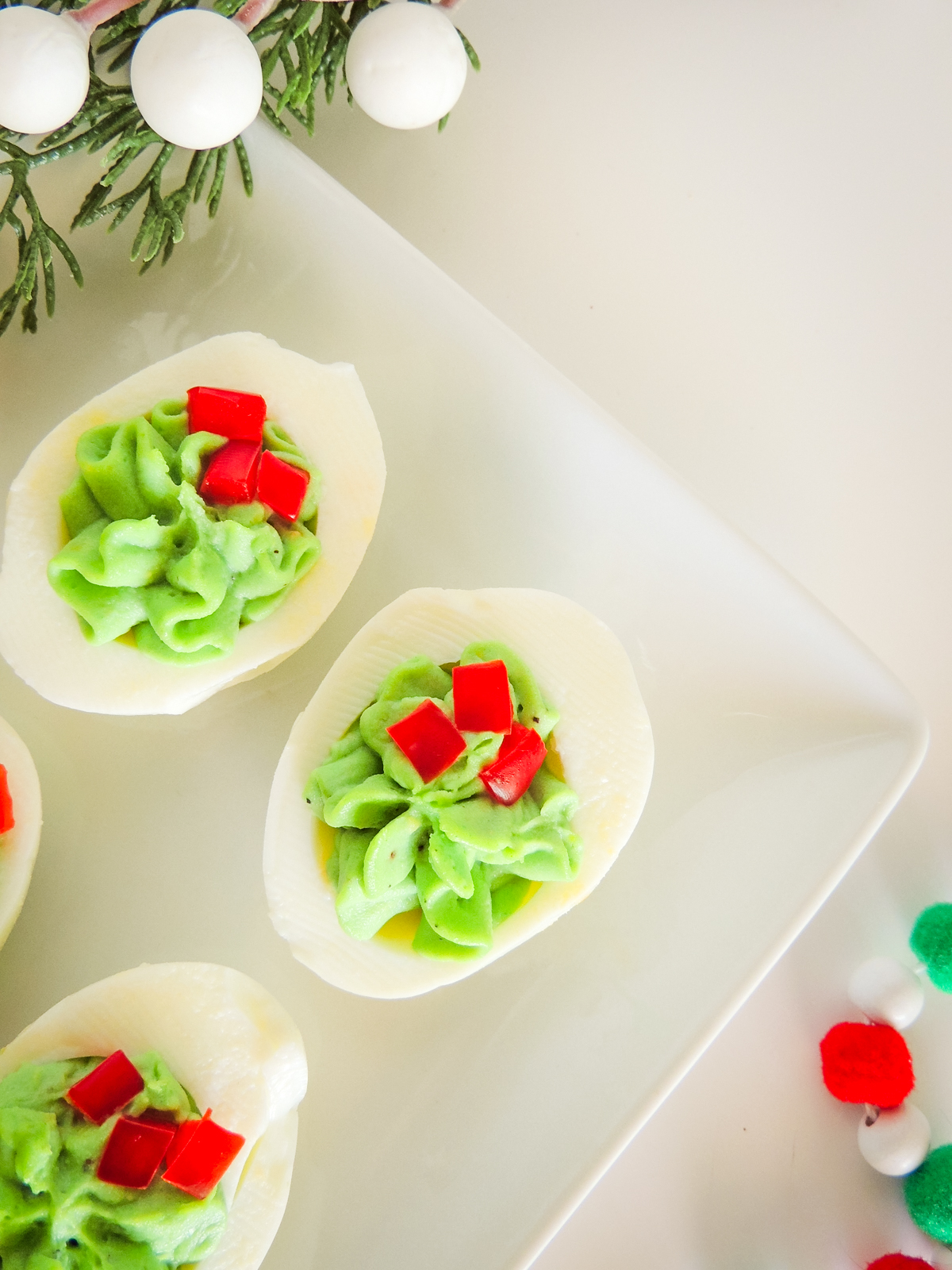 A tray with three Christmas wreath deviled eggs.