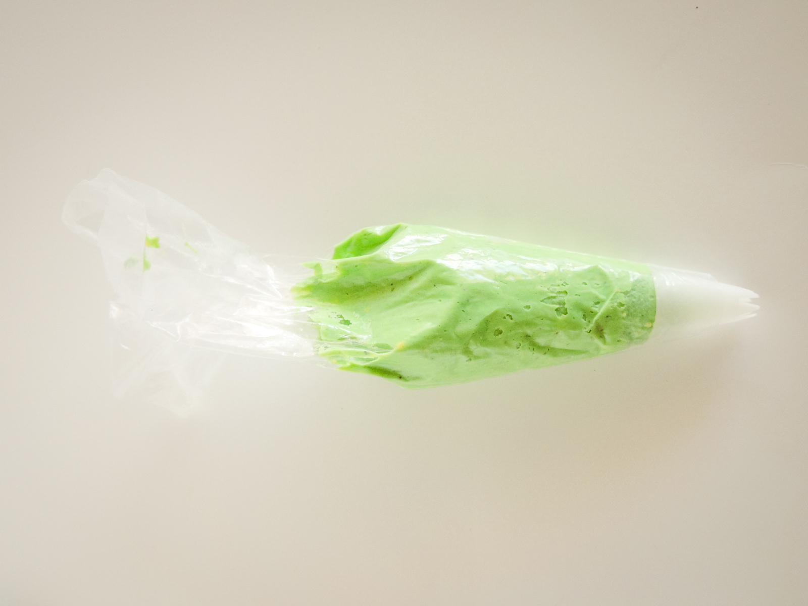 A piping bag filled with green deviled egg filling.