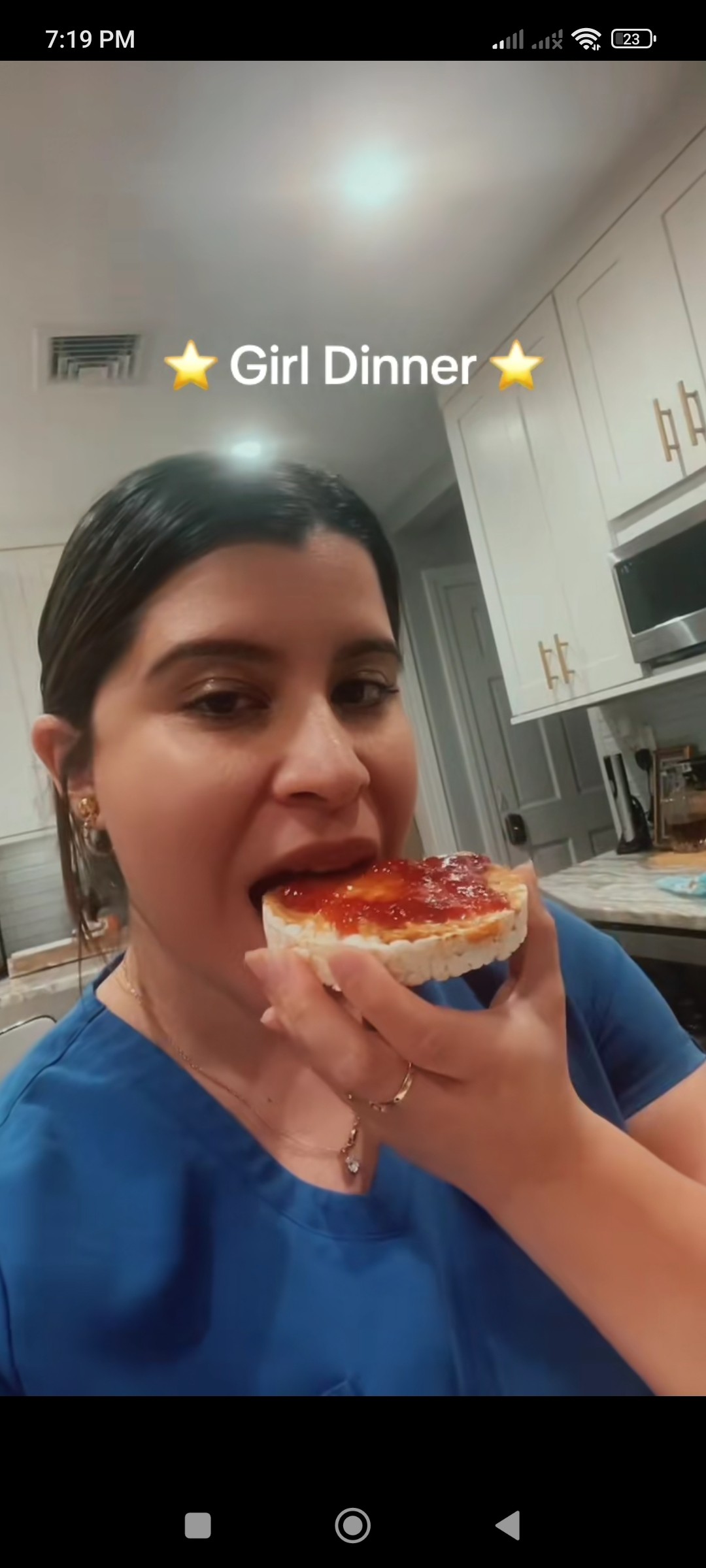 A woman eating a rice cake with peanut butter and jam on it. 
