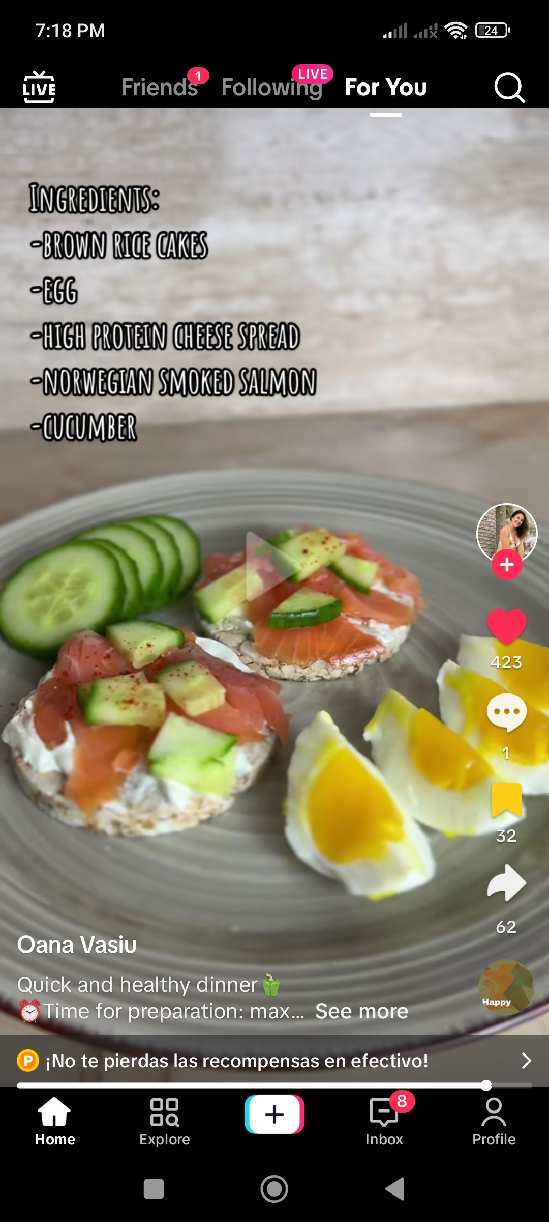 Two rice cakes with smoked salmon and cream cheese and cucumbers in the background and a sliced hard boiled egg.