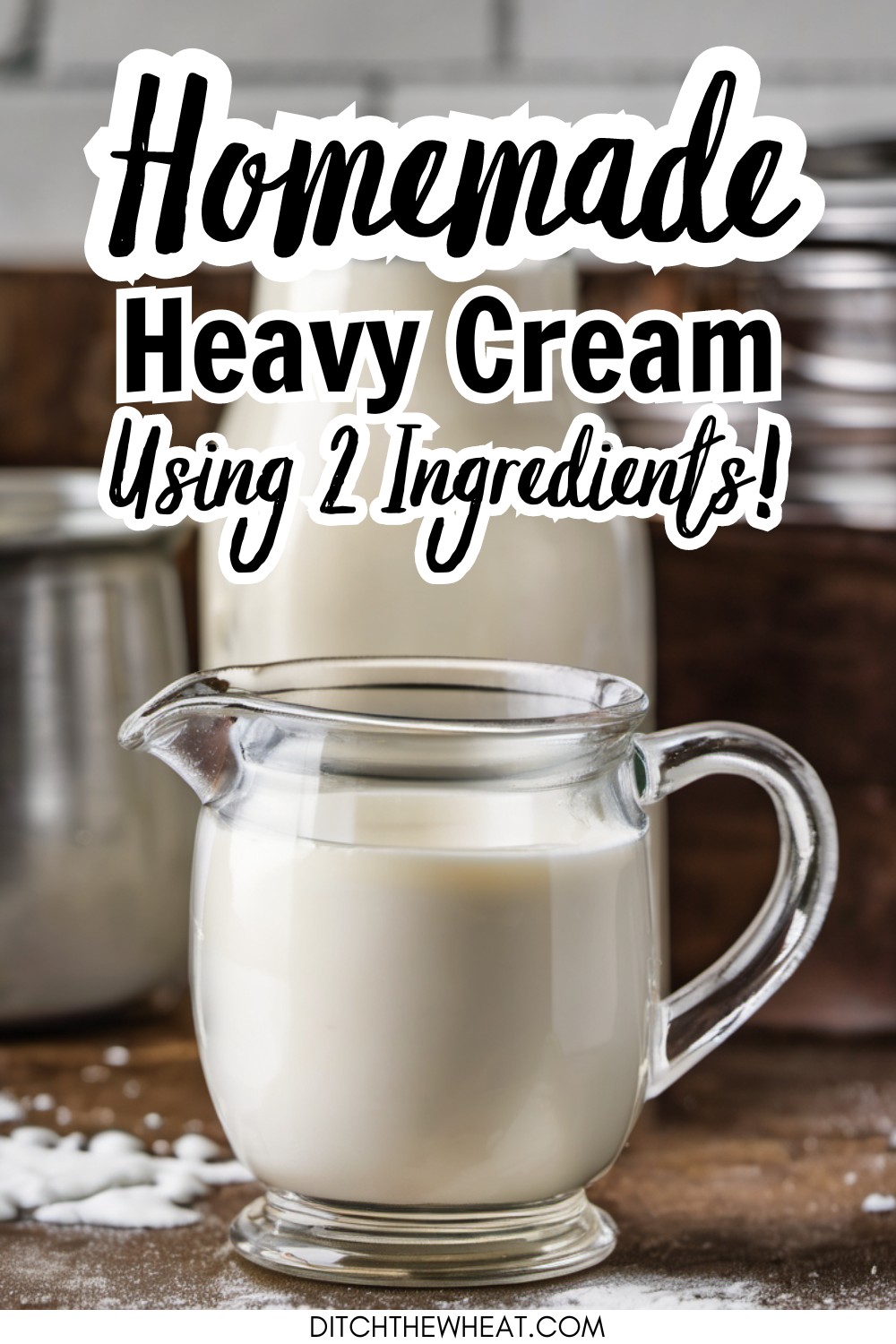 A glass creamer filled with heavy cream and a milk jug behind it.