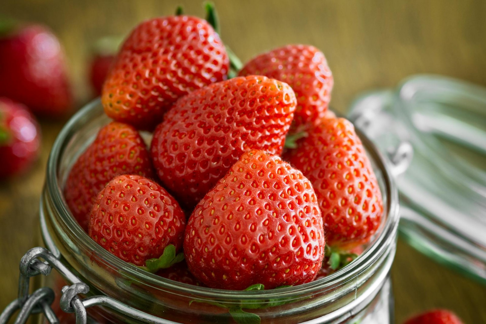 Fresh strawberries overflowing in a mason jar.