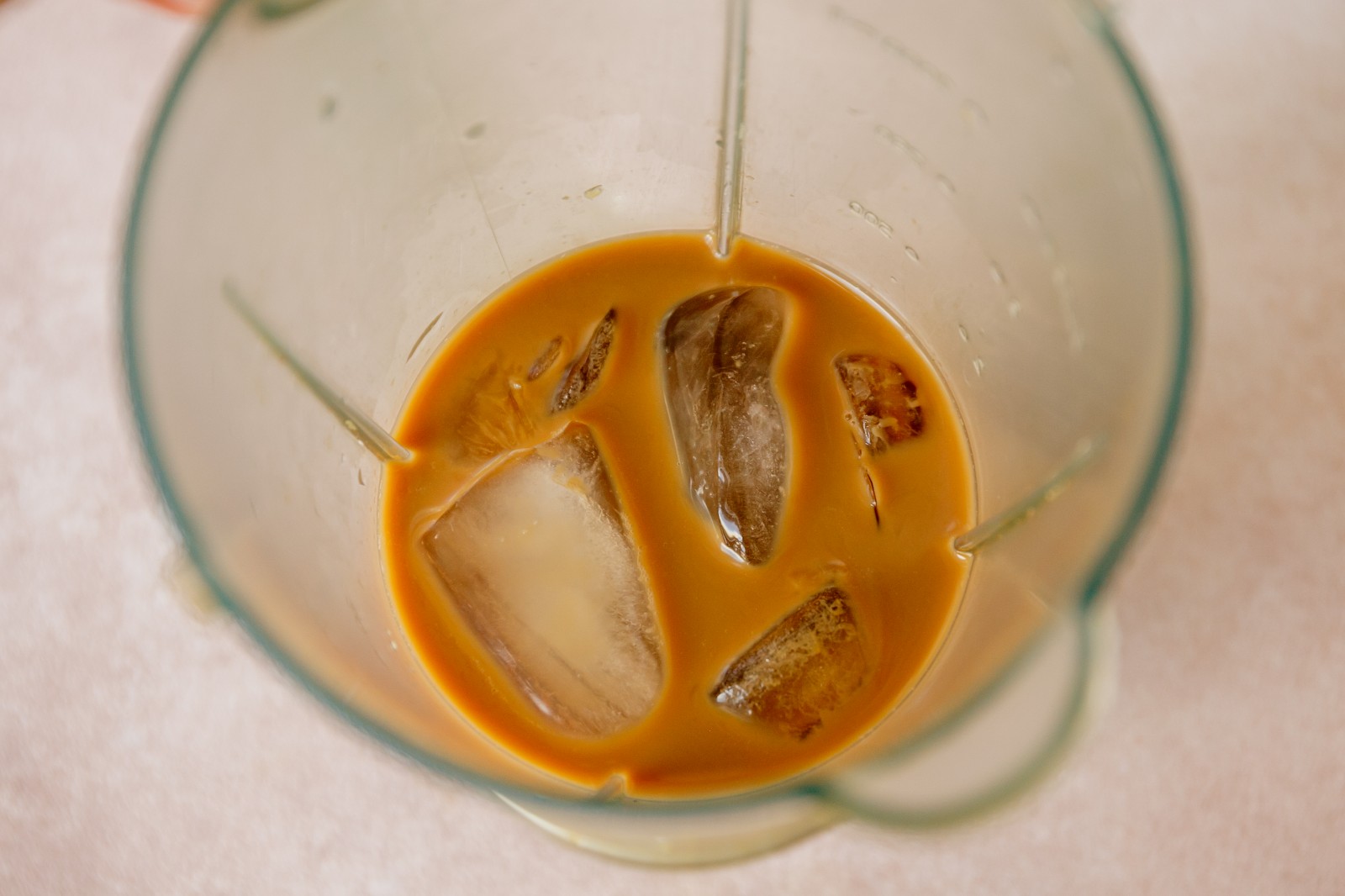 A blender filled with coffee and ice cubes.