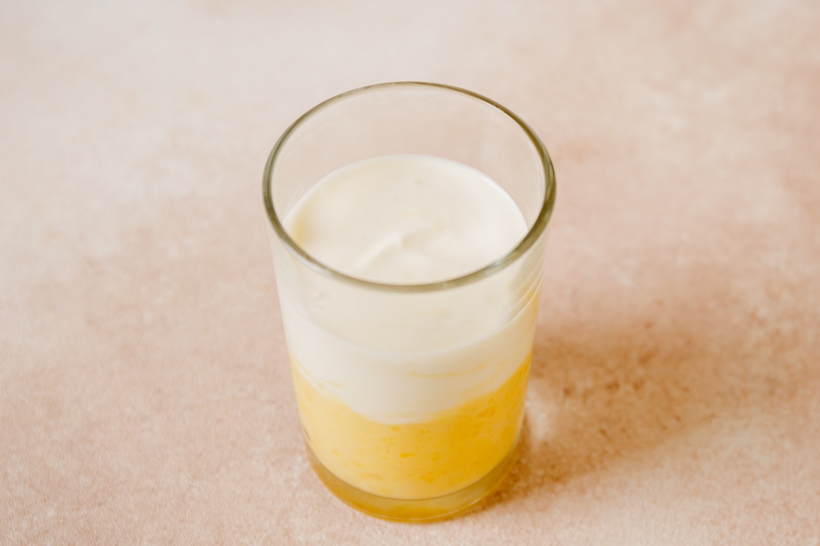 A glass filled with blended banana and whipped cream.