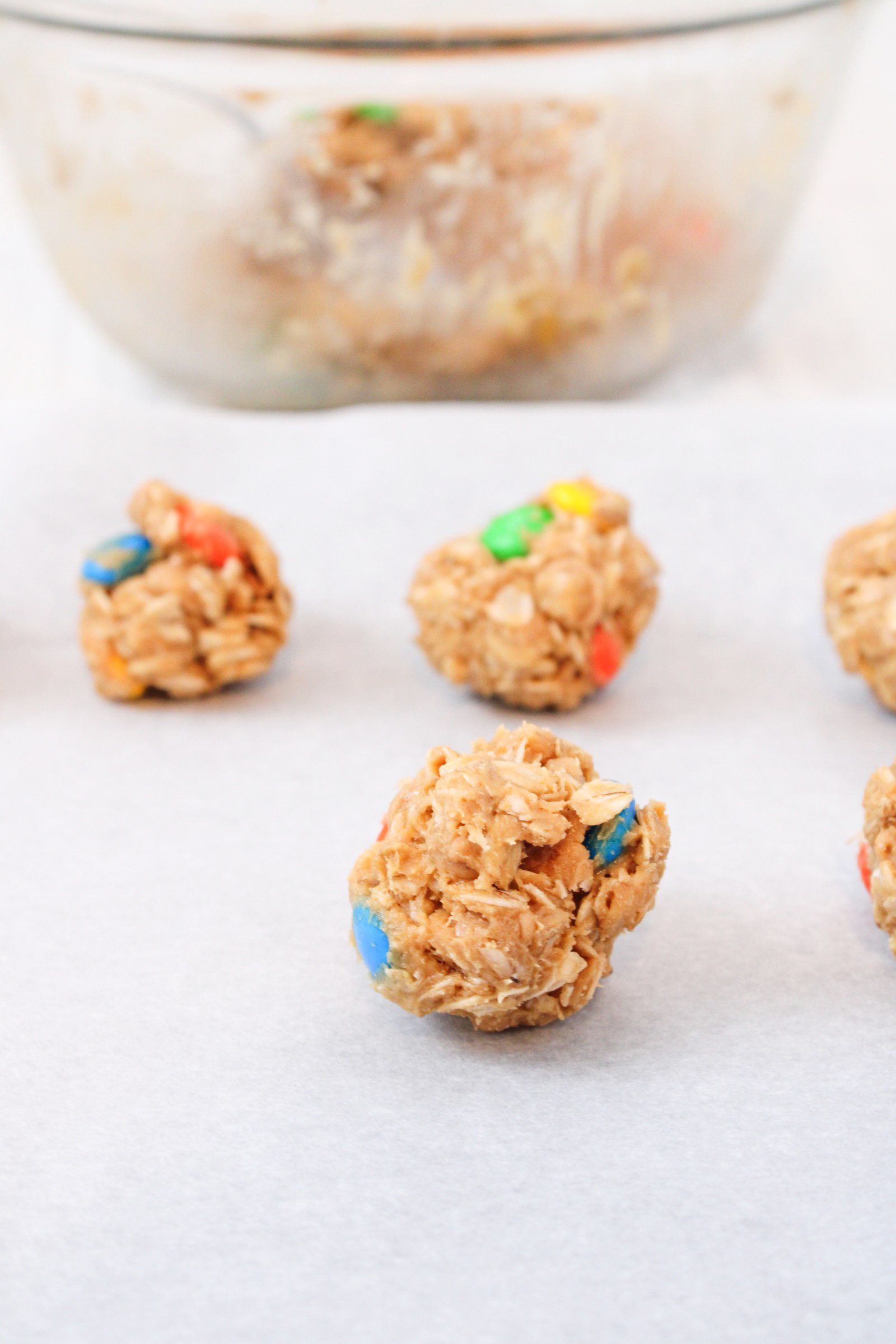 Forming the monster cookie balls and placing them on parchment paper.