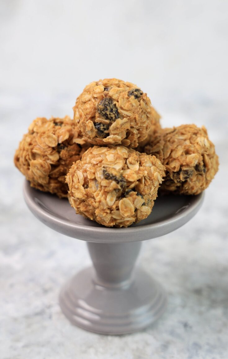 A grey dessert stand with a couple of oatmeal raisin balls.