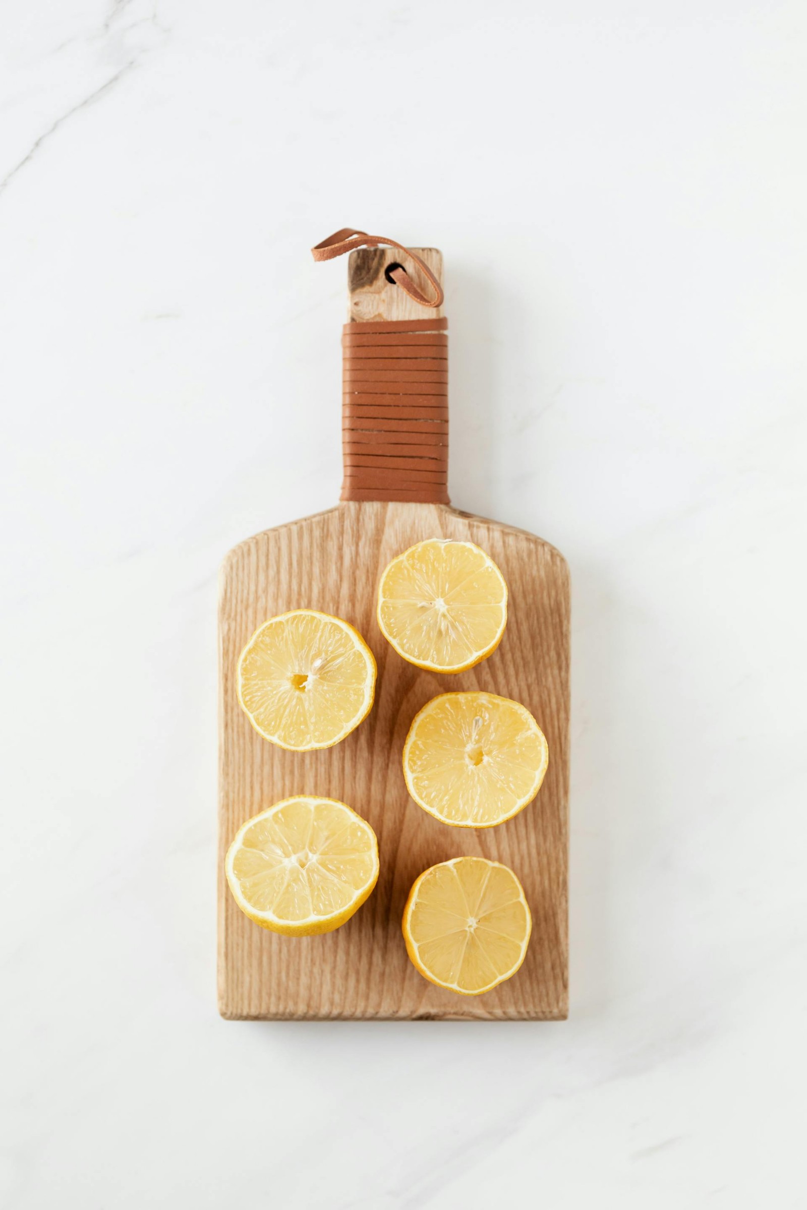 A wooden cutting board with sliced lemons.