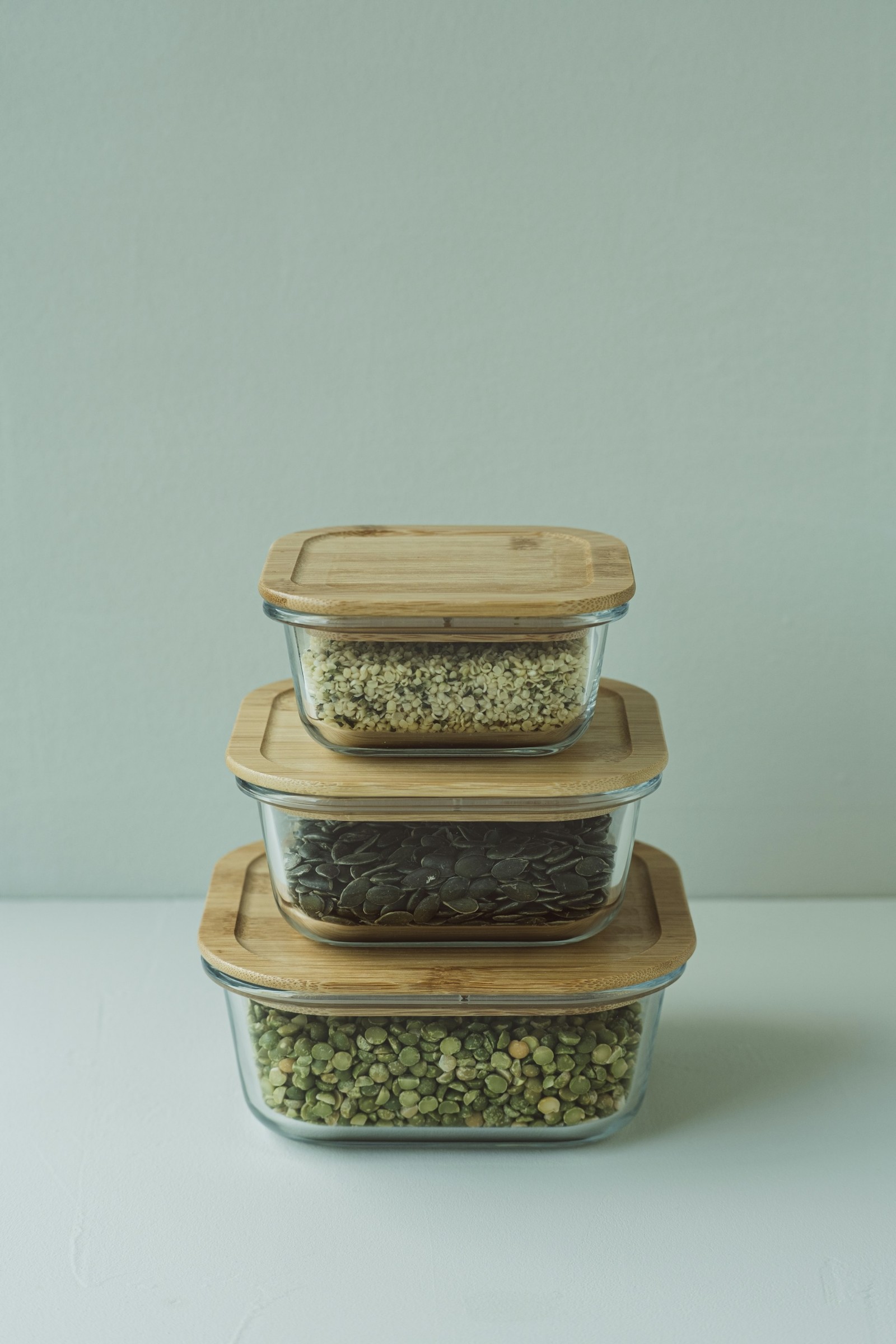 Three glass storage containers filled with lentils and rice.