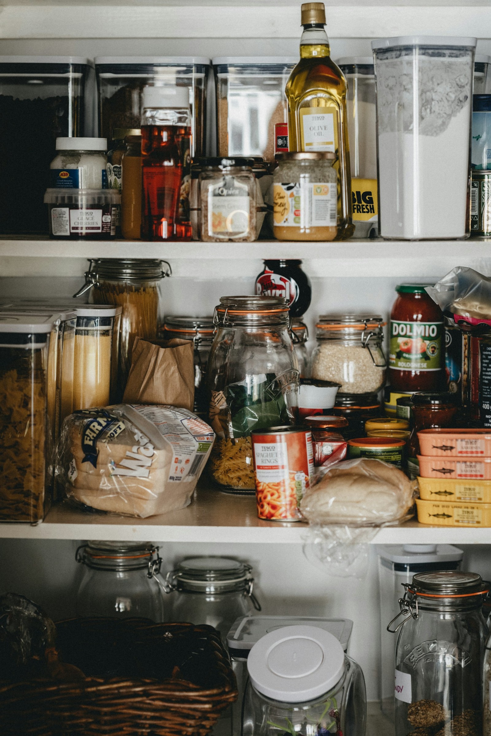 An unorganized pantry filled with packages of food and canned food.