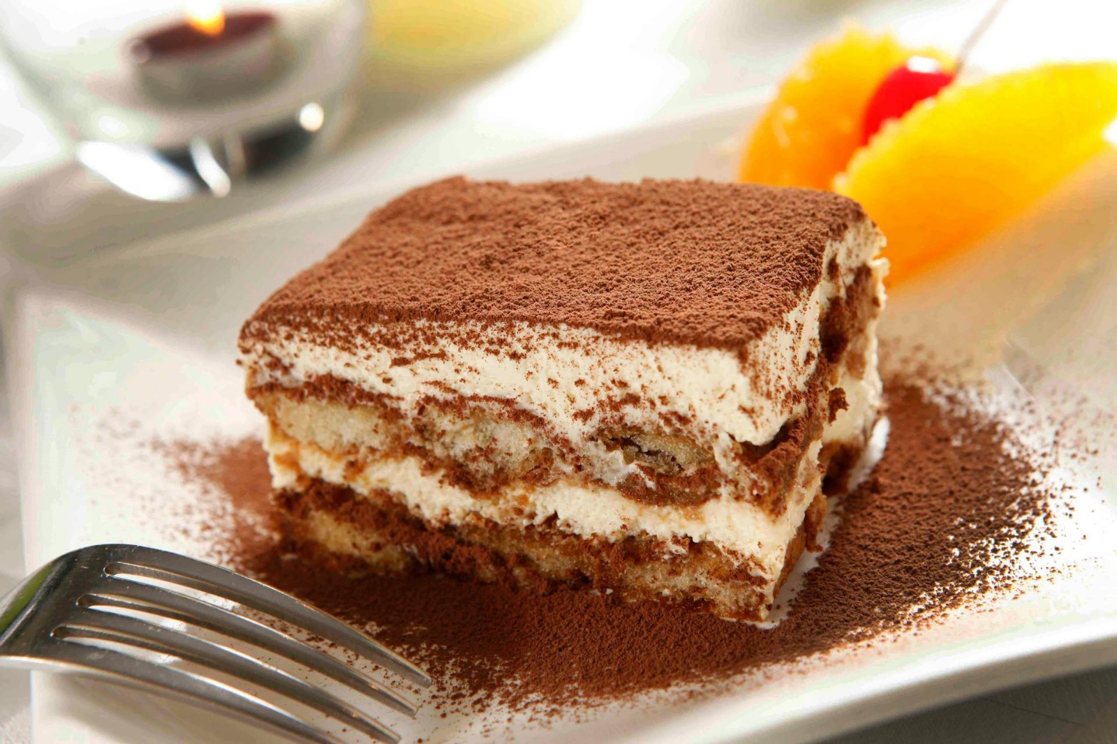 A slice of tiramisu on a white plate.