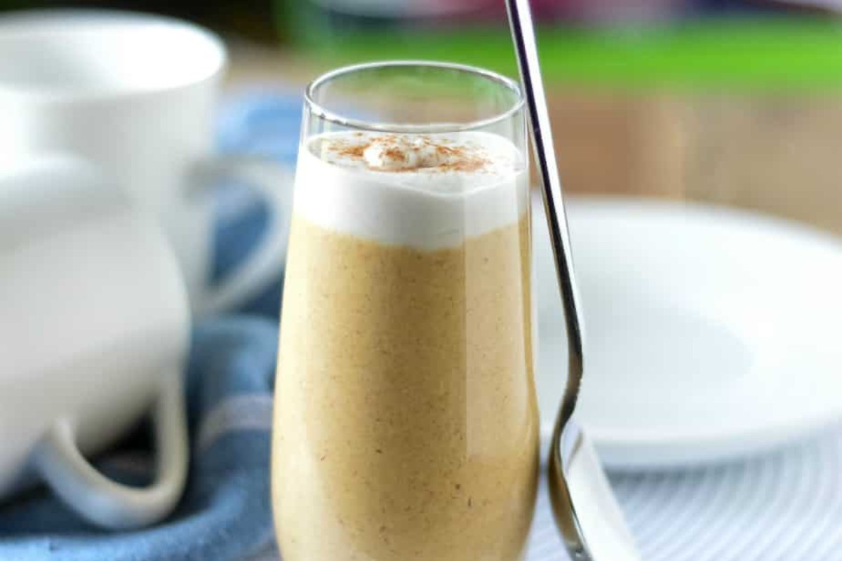 A glass with healthy pumpkin pudding and a spoon.
